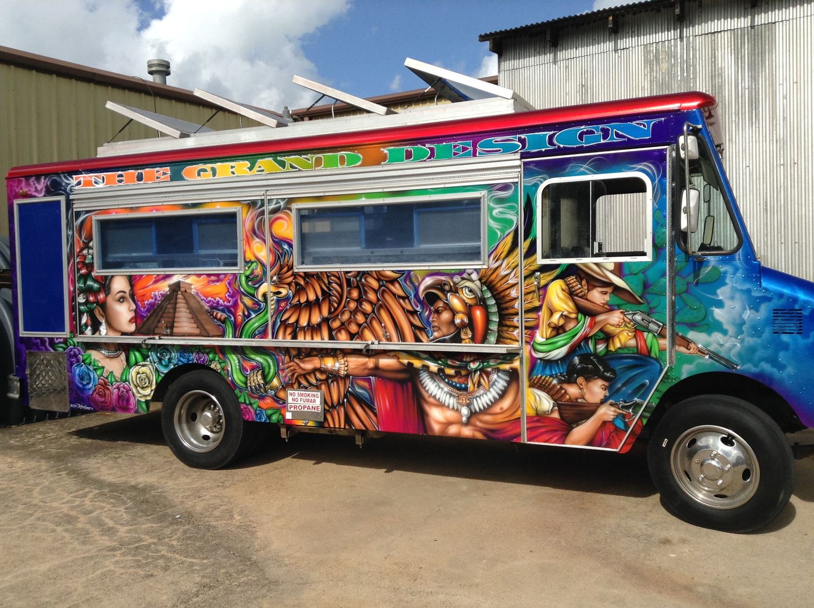 A step-van food truck painted along its whole side with a woman's portrait, a stepped pyramid, an eagle warrior in a feathered headdress and revolution-era figures, in saturated reds, golds and blues.